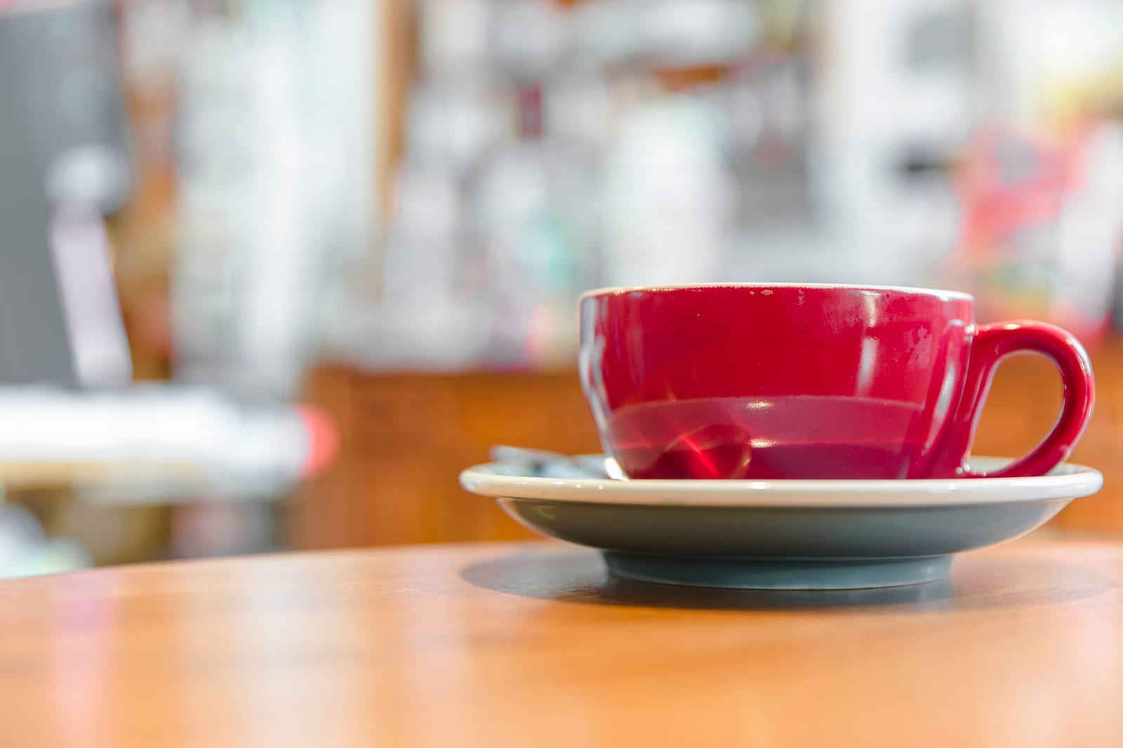 Xícara de café vermelha sobre mesa de madeira
